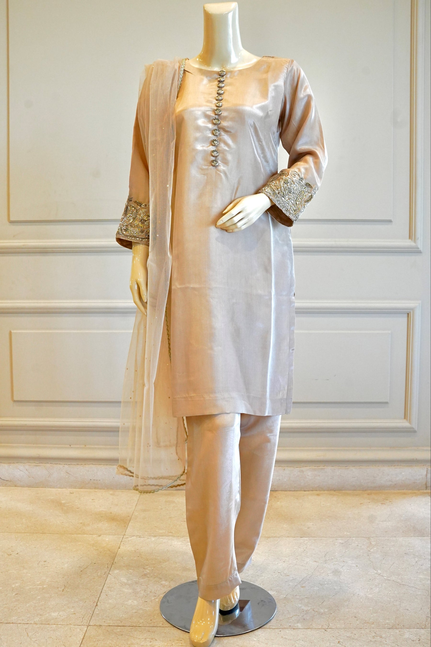 Mannequin wearing a light pink traditional outfit with a white background